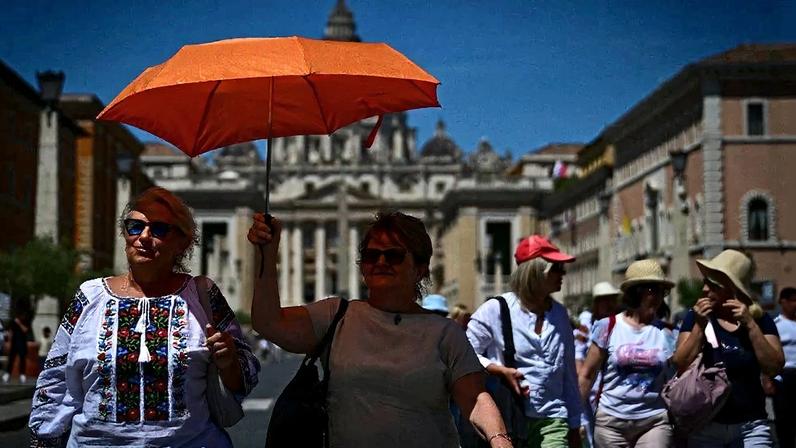 Turistas tentam se proteger do calor no Vaticano – Foto: Tiziana Fabi/AFP