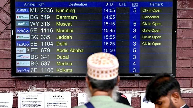 Um passageiro observa um painel de informações de voos no Aeroporto Internacional Hazrat Shahjalal, em Dhaka, em 3 de março de 2026, após as companhias aéreas cancelarem voos em meio ao conflito no Oriente Médio. Foto: Munir UZ ZAMAN / AFP