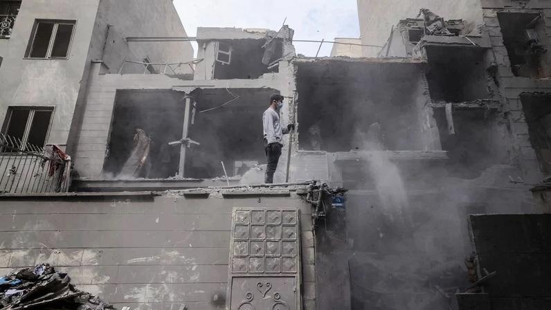 Homem observa os destroços de prédios residenciais após ataque a Teerã – foto: Atta Kenare/AFP
