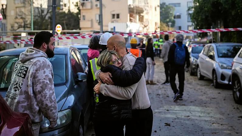 People react at the site of an Iranian missile strike in Tel Aviv, Israel, Tuesday, March 24, 2026.