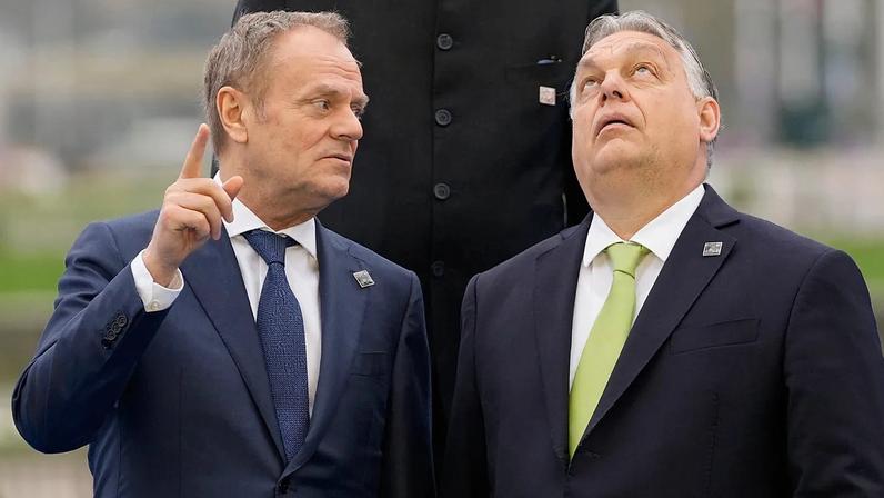 Hungary's Prime Minister Viktor Orban, right, speaks with Poland's Prime Minister Donald Tusk as they pose for a group photo during an Nuclear Energy Summit, March 2024