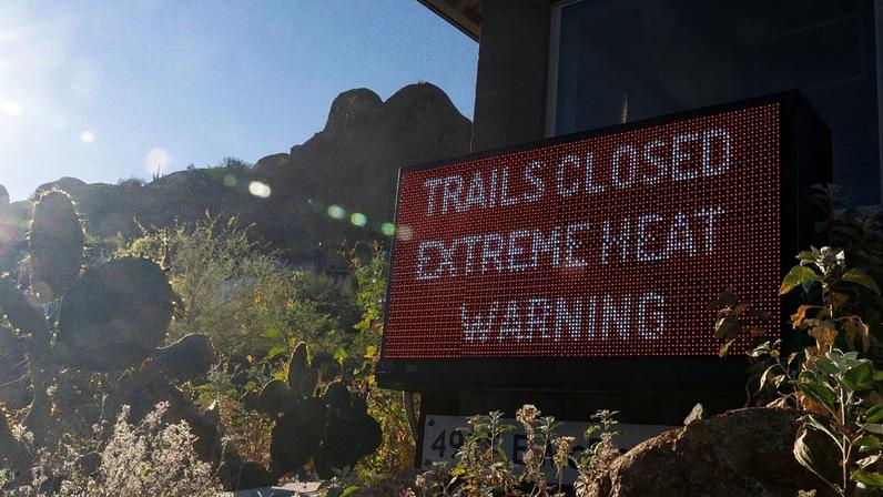 A sign warns hikers of trail closures due to extreme heat at Camelback Mountain on Thursday, March 19, 2026, in Phoenix.
