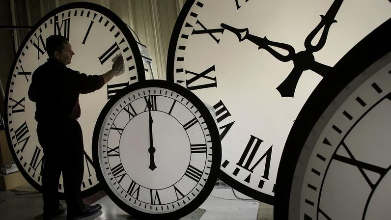 FILE: Electric Time Co. employee Walter Rodriguez cleans the face of an 84-inch Wegman clock.