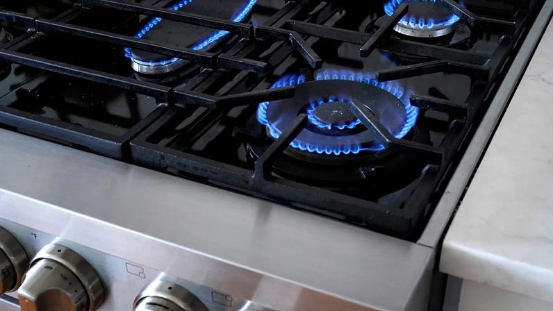 Flames emerge from burners on a natural gas stove.
