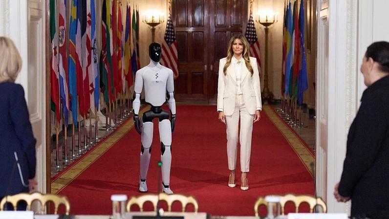 First lady Melania Trump arrives, accompanied by a robot, to attend the "Fostering the Future Together Global Coalition Summit"