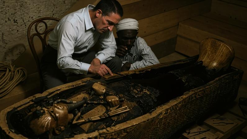 O arqueólogo Howard Carter e um auxiliar examinam o caixão do faraó Tutancâmon