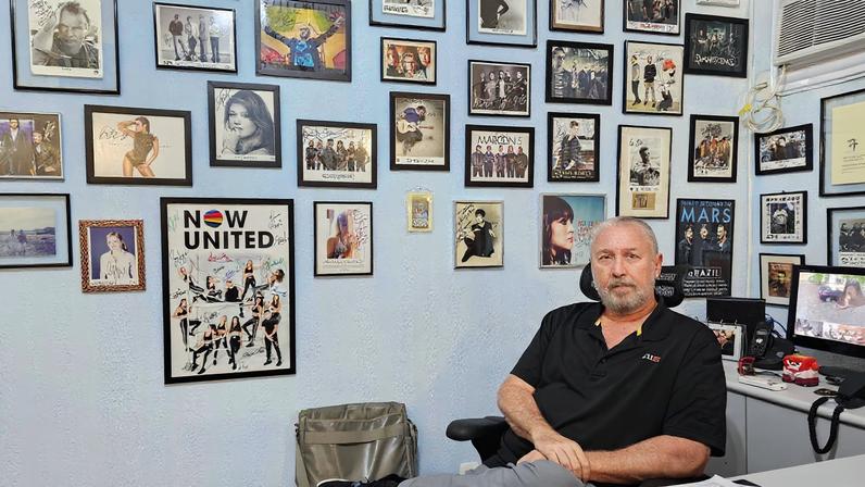 Renato da Silva em seu escritório, que tem fotos autografadas de artistas com quem ele trabalhou