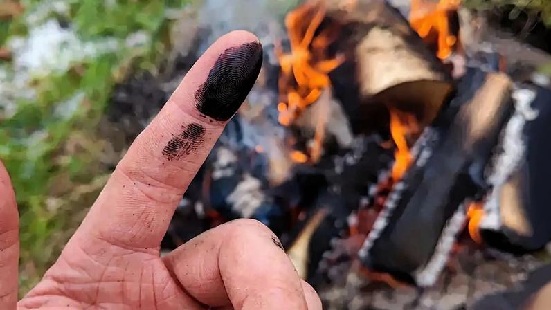 Fotografia de um dedo com carvão.