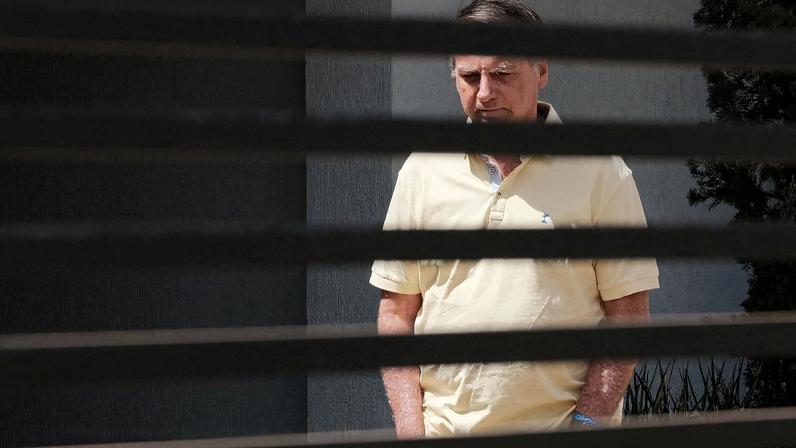 Brazil's former President Jair Bolsonaro stands at his home while under house arrest, amid the final phase of his trial, accused of plotting a coup after his electoral defeat, in Brasilia, Brazil, September 3, 2025. REUTERS/Diego Herculano REFILE - CORRECTING DATE FROM "SEPTEMBER 23" TO "SEPTEMBER 3"