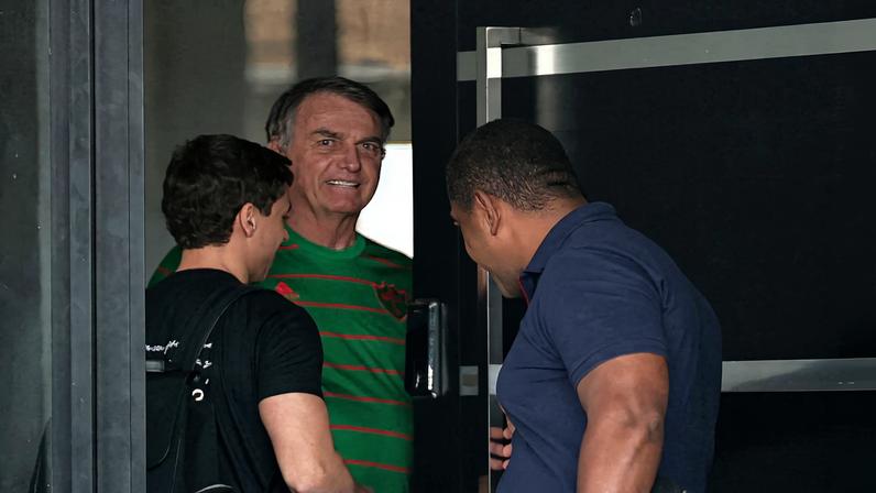 O ex-presidente do Brasil, Jair Bolsonaro, aparece na porta de sua casa, durante sua prisão domiciliar, em Brasília, Brasil, em 21 de novembro — Foto: Mateus Bonomi/Reuters