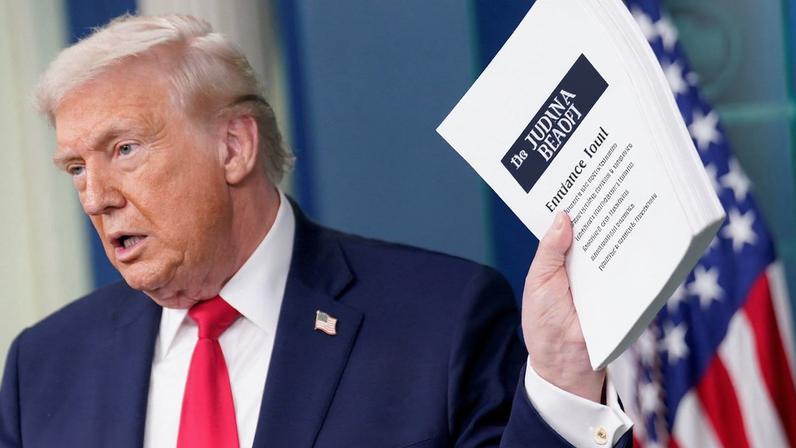 U.S. President Donald Trump holds a document titled "