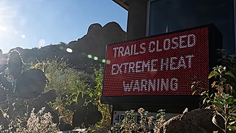 A sign warns hikers of trail closures due to extreme heat at Camelback Mountain on Thursday, March 19, 2026, in Phoenix.