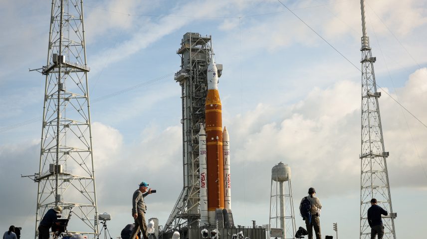 Pessoas posicionam câmeras para fotografar a missão Artemis 2 da NASA, que visa orbitar a Lua, com o foguete lunar de última geração, o Sistema de Lançamento Espacial (SLS), e a cápsula tripulada Orion, na plataforma 39B, antes do lançamento da missão Artemis II no Centro Espacial Kennedy, em Cabo Canaveral, Flórida, EUA