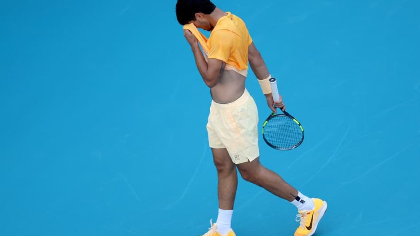 Carlos Alcaraz enxugando seu rosto durante confronto contra Sebastian Korda no Miami Open 2026 (Foto: Matthew Stockman/Getty Images via AFP)