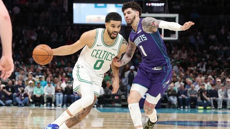 Jayson Tatum passando por LaMelo Ball durante partida entre Charlotte Hornets x Boston Celtics (Foto: Brock Williams-Smith / Getty Images via AFP)