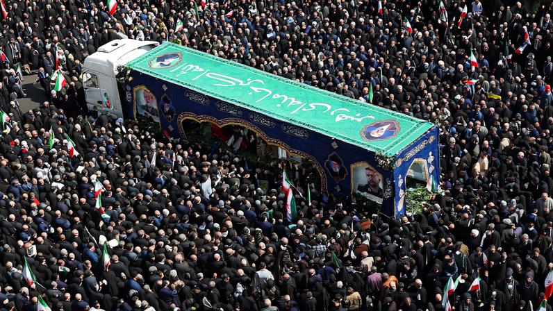 People gather around the coffin of Iranian security chief Ali Larijani during a funeral for Larijani and victims of the IRIS Dena warship at Enghelab Square, amid the U.S.-Israeli conflict with Iran, in Tehran, Iran, March 18, 2026. REUTERS/Alaa Al Marjani