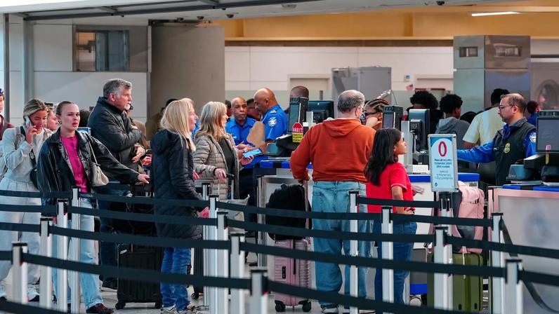 Passengers walk through a queue to enter a TSA security checkpoint at Ronald Reagan International Airport in Arlington, Virginia., U.S., March 15, 2026. REUTERS/Aaron Schwartz