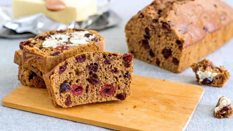 Pão de frutas Barmbrack servido em tábua de madeira com manteiga