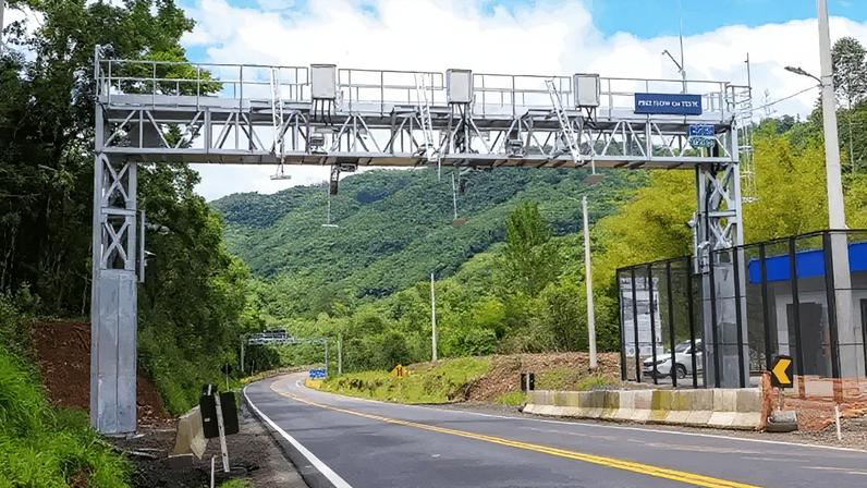 O free flow é um sistema de cobrança eletrônica automática que elimina praças físicas e cancelas, permitindo que veículos passem por pórticos sem reduzir a velocidade; na imagem, trecho de rodovia da concessionária Caminhos da Serra Gaúcha