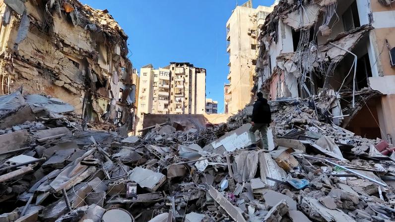 A man stands near a damaged building after an Israeli strike on Beirut's southern suburbs