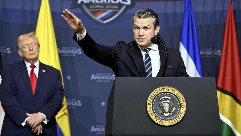 O secretário de Defesa dos EUA, Pete Hegseth, com o presidente Donald Trump ao fundo, na reunião 'América Contra os Cartéis', na Flórida, em 7 de março de 2026. Foto: Saul Loeb/AFP