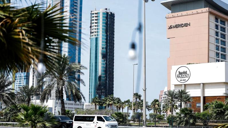 Vehicles drive past a building that was damaged by an Iranian drone attack, after Israel and the U.S. launched strikes on Iran, in Seef, Manama, Bahrain, March 1, 2026. REUTERS/Hamad I Mohammed