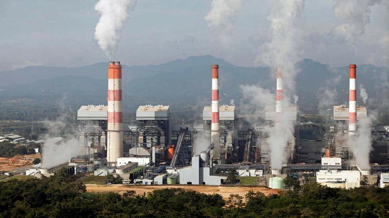 The large Mae Moh coal burning power plant releasing smoke from its stacks in the early morning. The power plant turns off the smoke in the morning then starts again at night.