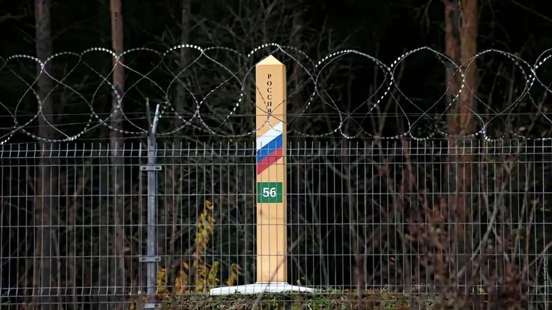 A Russian border marker stands behind barbed wire on the border between the Russian semi-exclave of Kaliningrad and Lithuania on October 28, 2022 near Vistytis, Lithuania.
