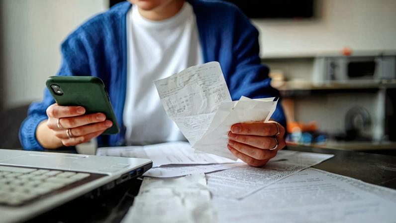 Pessoa organizando documentos e contas para ilustrar reportagem sobre como declarar investimentos no exterior