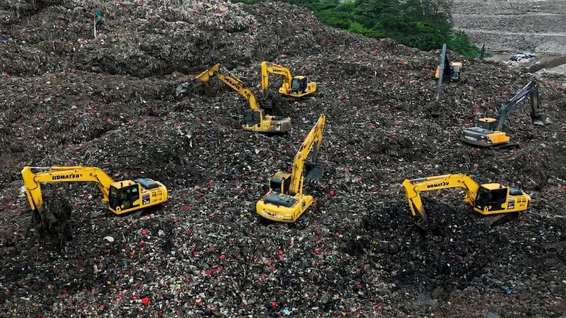 A drone view shows excavators operating amid garbage at the site of collapse at the Bantar Gebang landfill during a rescue operation in Bekasi