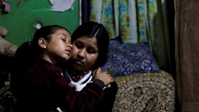 Saloni Subedi sits on the lap of her mother, Parbati Subedi, 28, wife of Dev Kumar Subedi, 29, who was shot dead during youth led protests that toppled Nepal's prime minister and prompted elections set for March 5, 2026, after her mother arrives home from work in Lalitpur, Nepal, February 22, 2026. REUTERS/Navesh Chitrakar