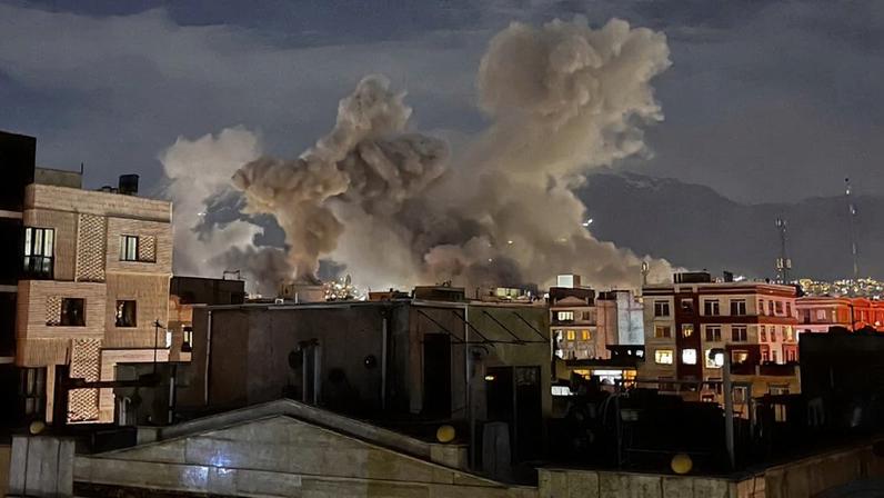 Plumes of smoke rise in the night sky above buildings in Tehran.