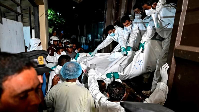 Profissionais de saúde carregam os corpos de marinheiros iranianos que morreram em um ataque americano contra a fragata IRIS Dena, na costa sul do Sri Lanka, em 4 de março de 2026.