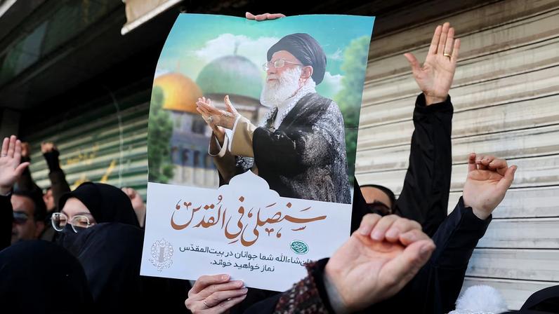 A woman holds a poster with the picture of Iran's Supreme Leader Ayatollah Ali Khamenei as people gather after Khamenei was killed in Israeli and U.S. strikes on Saturday, in Tehran, Iran, March 1, 2026.
