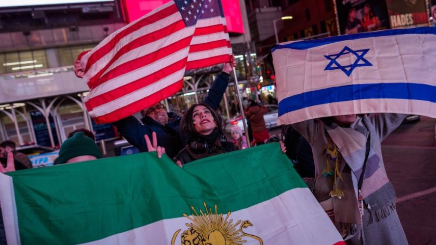 People hold a pre-revolution Iranian flag, a U.S. flag, and an Israeli flag during a “Freedom for Iran” rally in Times Square in New York on March 2.