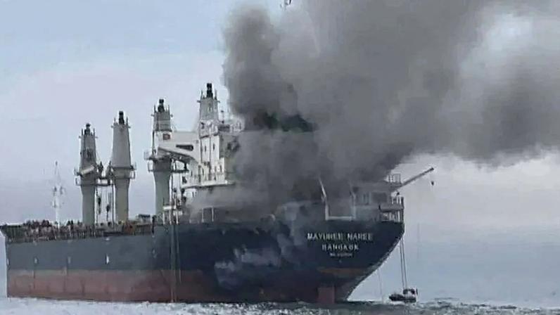 Smoke rises from a Thai-flagged bulk carrier near the Strait of Hormuz.