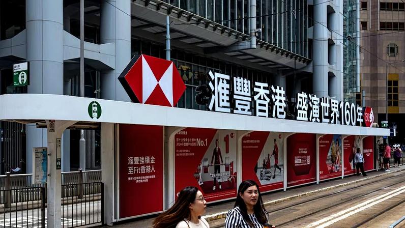 The HSBC Holdings Plc logo atop a tram station outside the bank's headquarters building in Hong Kong, China, on Monday, July 28, 2025. HSBC is scheduled to release earnings results on July 30. Photographer: Lam Yik/Bloomberg