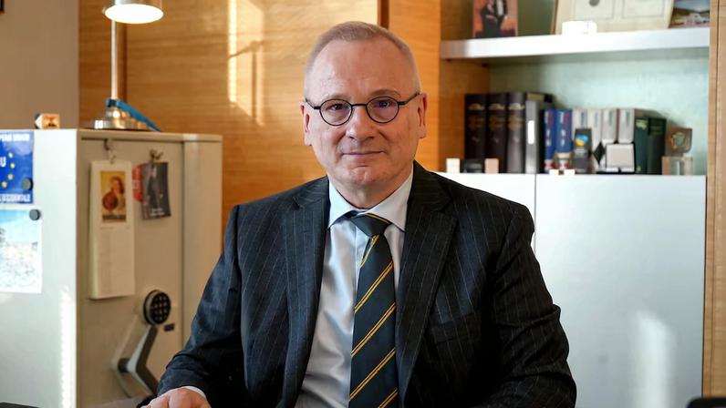 Robert in den Bosch sits at a desk in his office in Geneva