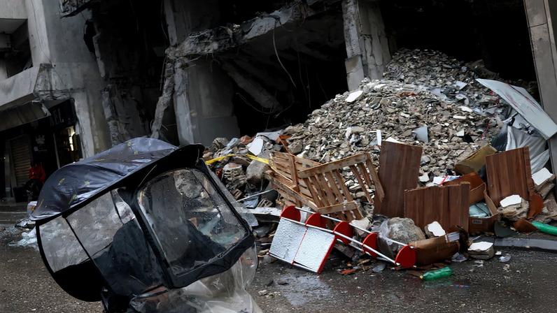 A man rides a scooter next to a damaged building in the aftermath of an Israeli strike in central Beirut