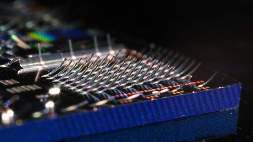 Photonic chip covered in microscopic structures that curl upward