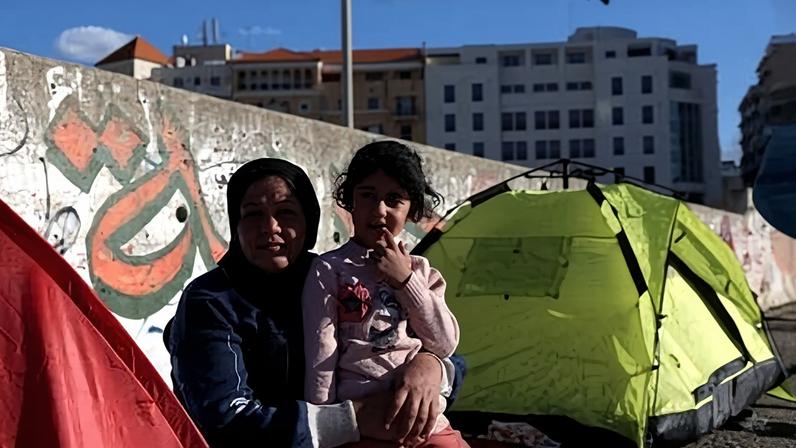 Mulher e criança de família deslocada posam em frente a uma barraca após a escalada dos conflitos entre o Hezbollah e Israel, em meio ao conflito de EUA-Israel contra o Irã, em Beirute, Líbano