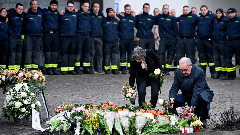 El presidente suizo, Guy Parmelin, y su esposa, Caroline Parmelin, rinden homenaje a las víctimas en el lugar donde l martes se incendió un autobús en Kerzers (Suiza).