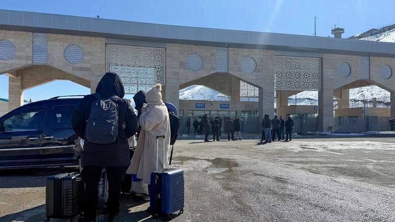People stand at the Kapikoy border crossing between Turkey and Iran, in eastern Van province, Turkey, March 1, 2026. REUTERS/Ismet Mikailogullari