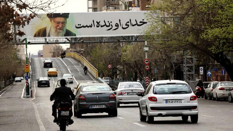 People drive near a banner of Iran's late Supreme Leader Ayatollah Ali Khamenei on a street, after he was killed in Israeli and U.S. strikes on Saturday, in Tehran, Iran, March 2, 2026. Majid Asgaripour/WANA (West Asia News Agency) via REUTERS