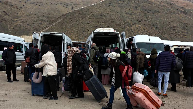 People wait for transportation to the city center after crossing from Iran into Turkey at the Kapikoy Border Gate in eastern Van province, Turkey, March 2, 2026. REUTERS/Dilara Senkaya