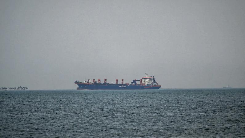 A commercial ship is viewed anchored off the coast of the United Arab Emirates, in the Strait of Hormuz.