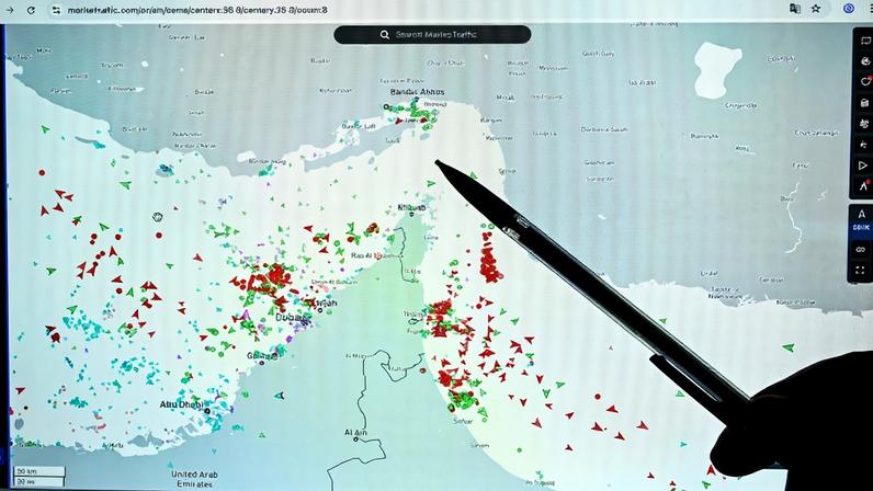 A person points at a page on the MarineTraffic website that shows traffic on the edge of the Strait of Hormuz, in Paris on March 4.