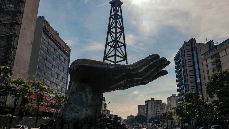 Uma estátua de uma mão segurando uma torre de perfuração perto da sede da empresa estatal de petróleo da Venezuela em Caracas. Crédito: Adriana Loureiro Fernandez para o The New York Times