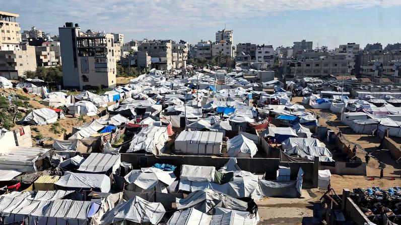 Palestinians displaced during the two-year Israeli offensive, shelter at a tent camp in Gaza City
