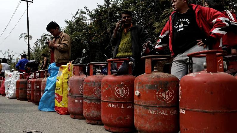 People stand in a queue with their empty LPG cylinders outside a depot of Nepal Gas Industries Pvt. Ltd. amid the U.S.-Israeli conflict with Iran, in Kathmandu